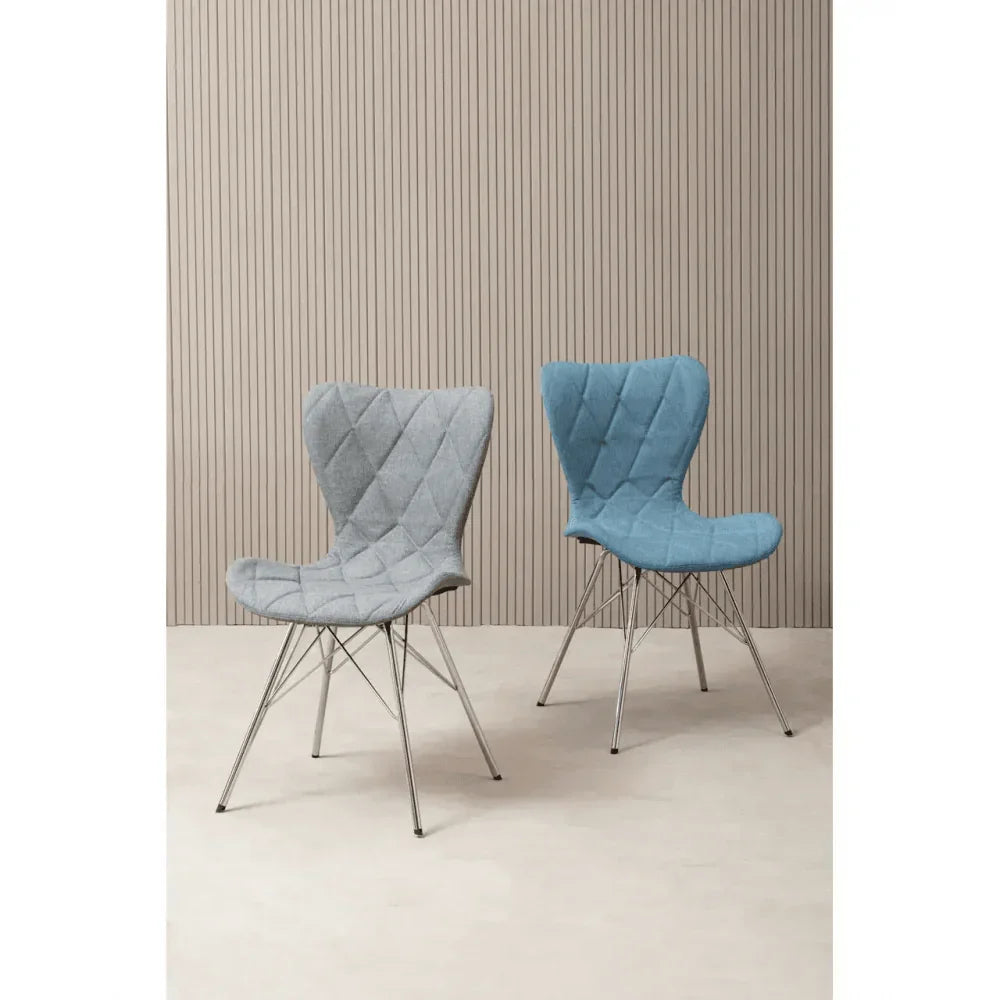 Grey and blue upholstered dining chairs with metal legs on light flooring