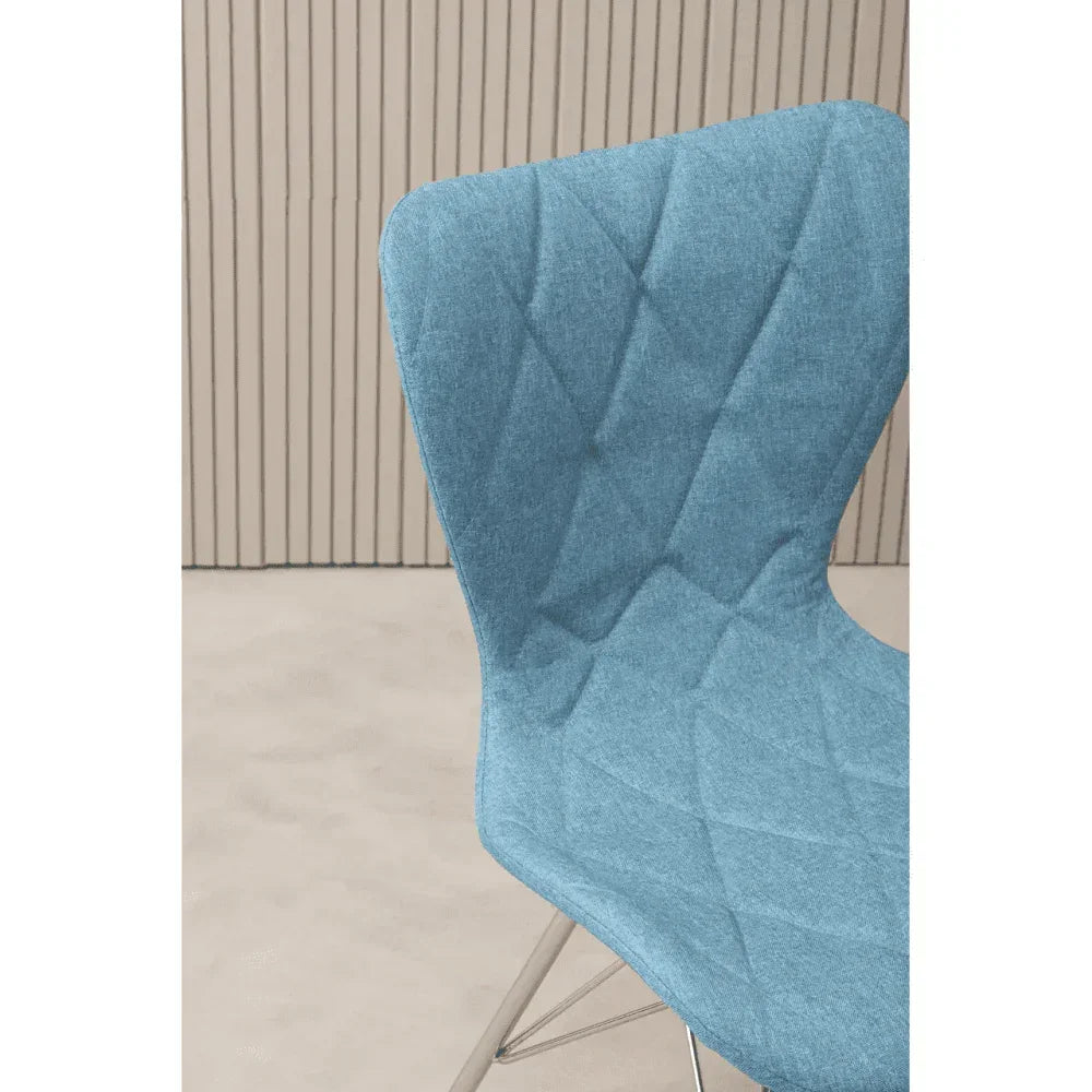 Blue fabric dining chair with diamond stitch detail and metal legs, close side view