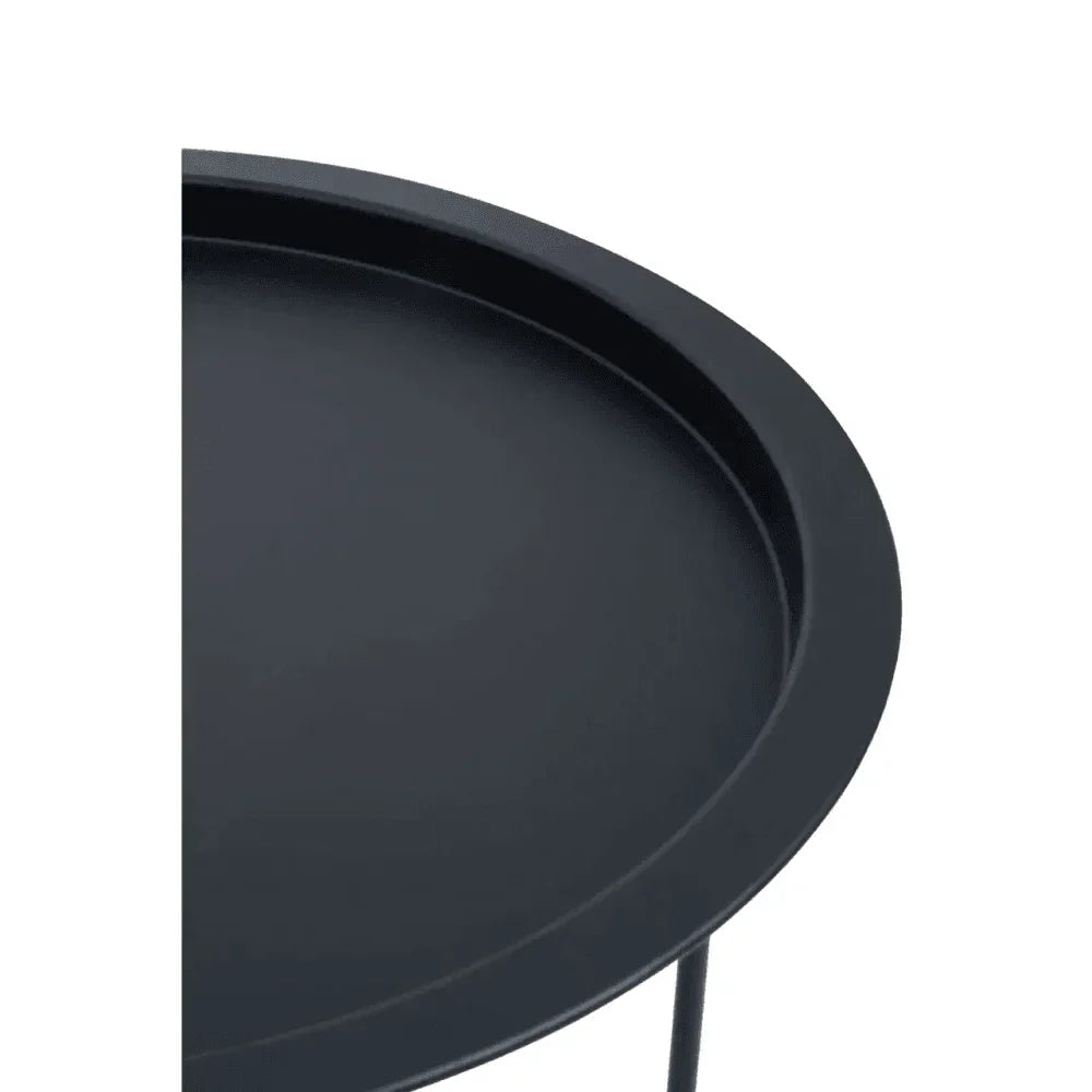 Closeup of round black metal side table with raised edge and thin legs