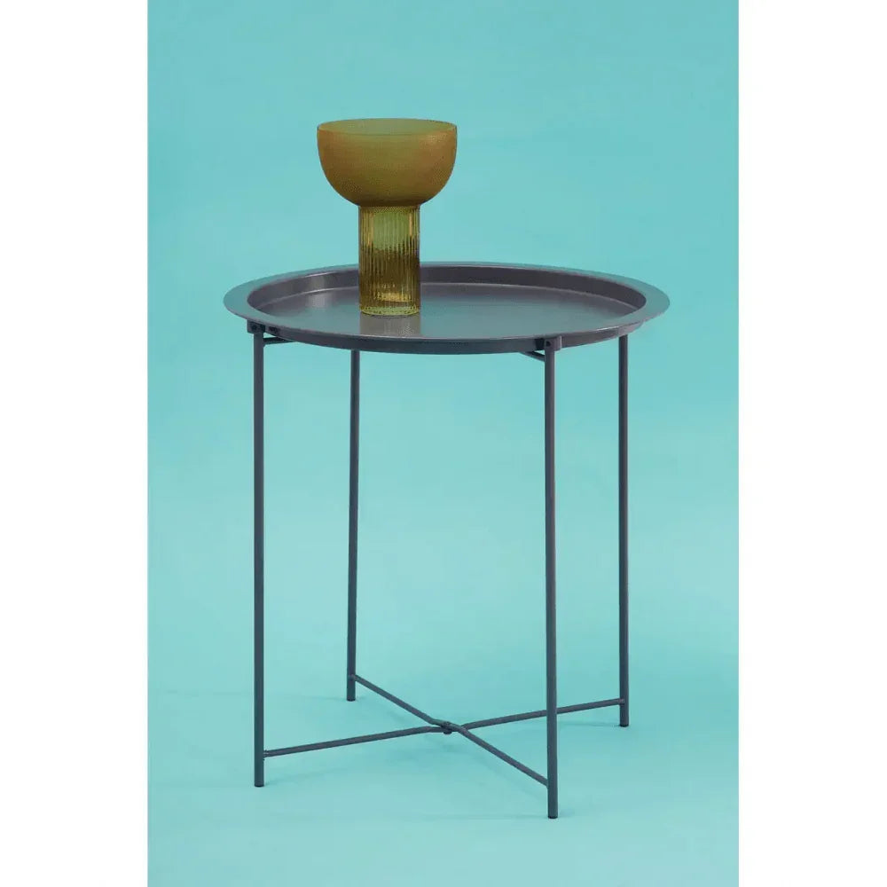 Round metal side table with slim black legs and decorative amber vase
