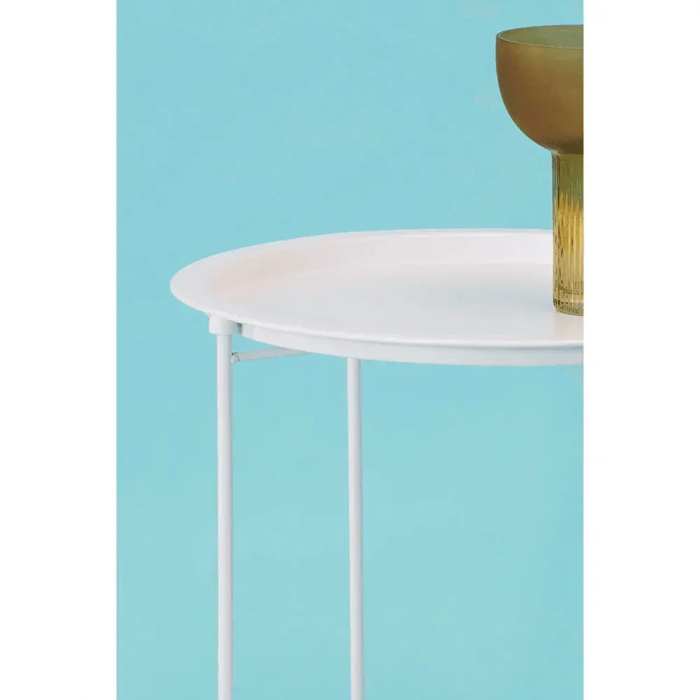 Round white metal side table with gold glass on light blue background