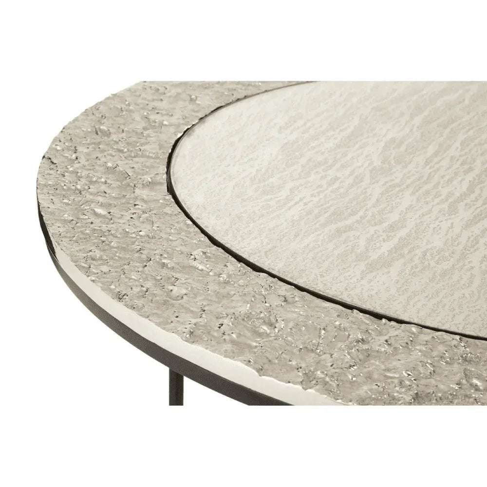 Round textured stone table top with metallic edge detail, close-up view