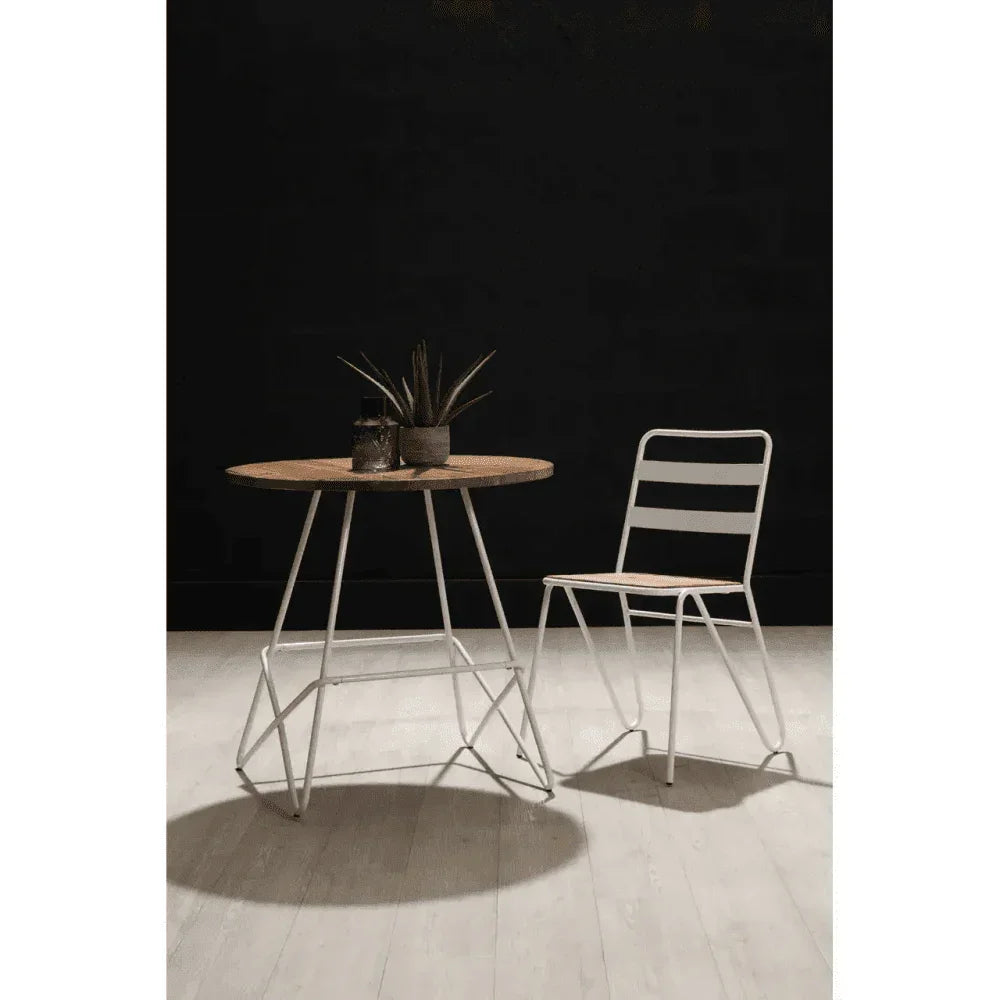 Round wood and metal dining table with matching chair on light flooring, black background