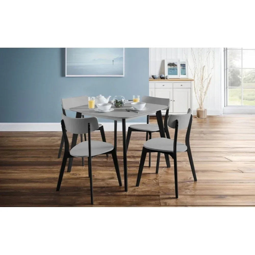 Modern grey dining table set with four chairs on wooden floor in bright dining room