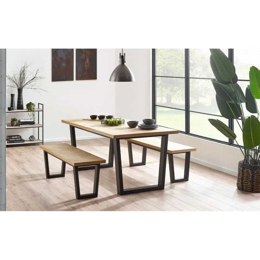 Modern dining table set with wood top and black metal legs, two benches, in bright room