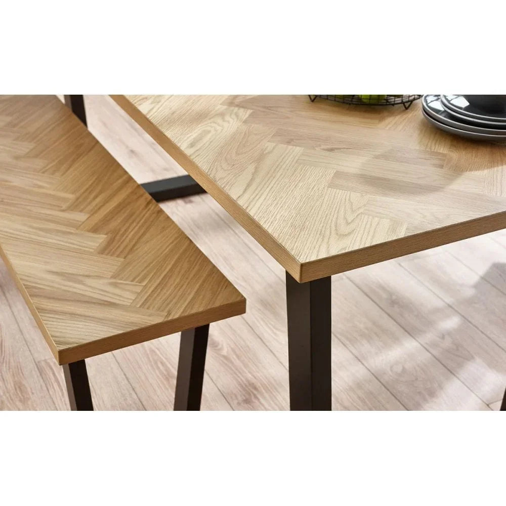 Light oak dining table and bench set with herringbone wood pattern and black legs