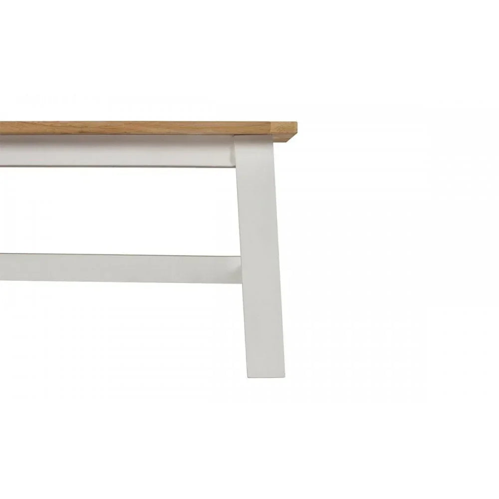 Close up of dining table leg with white frame and light oak wood top