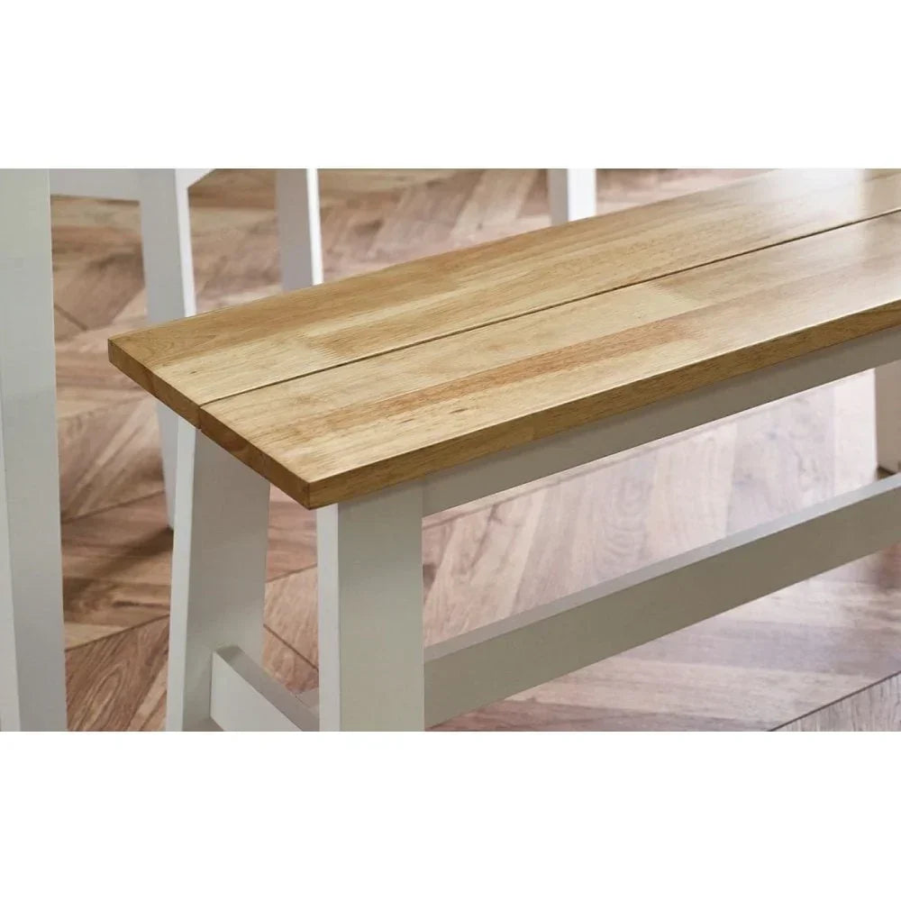 Oak dining bench with natural wood seat and white painted legs on parquet floor