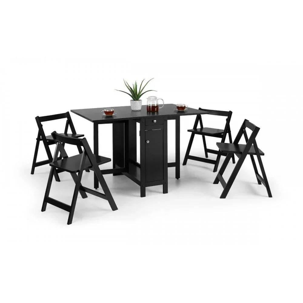 Black folding dining table set with four folding chairs and plant centerpiece