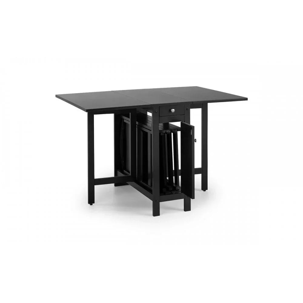 Black folding dining table with drop-leaf sides and nested chairs underneath