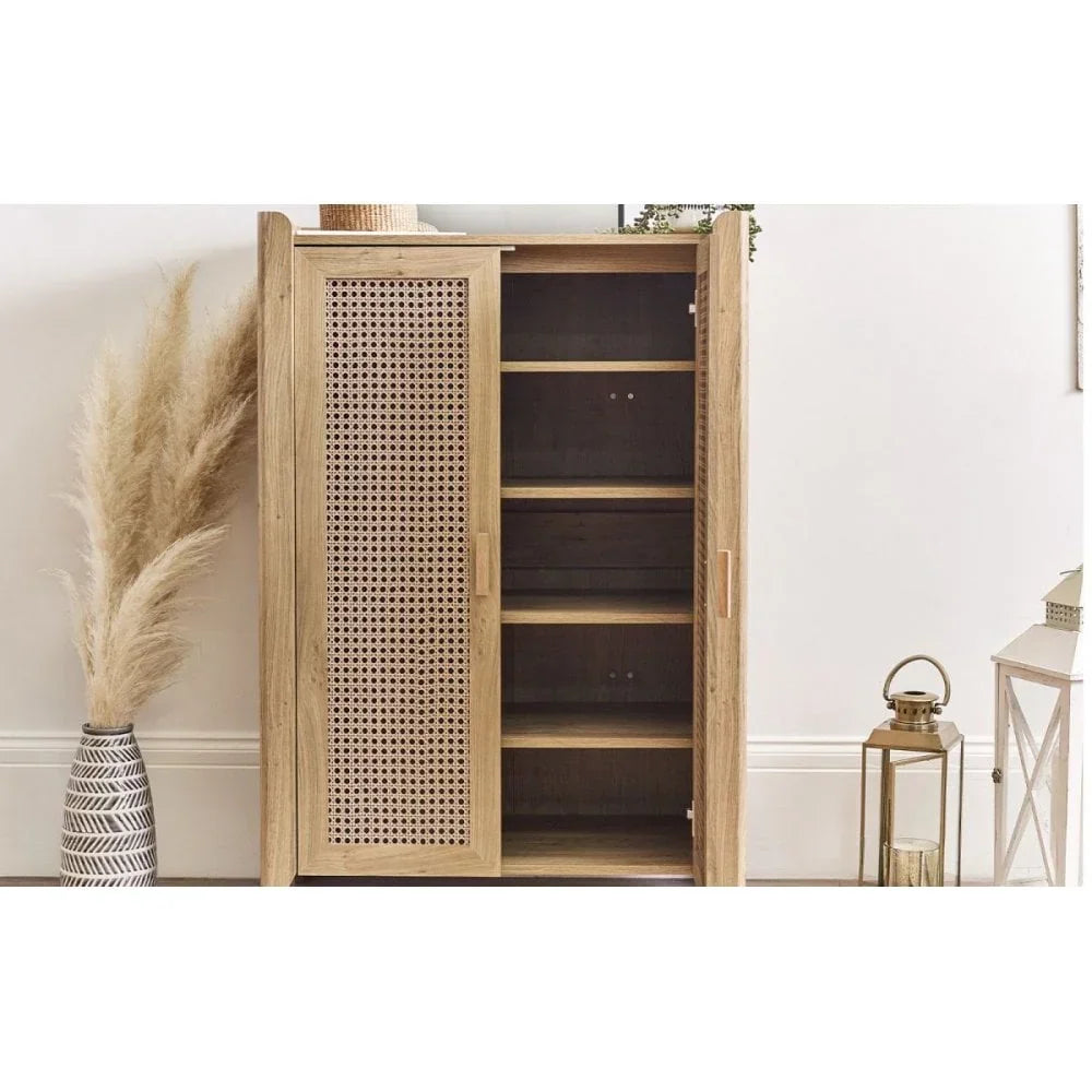 Natural wood storage cabinet with cane door and shelves in modern living room setting