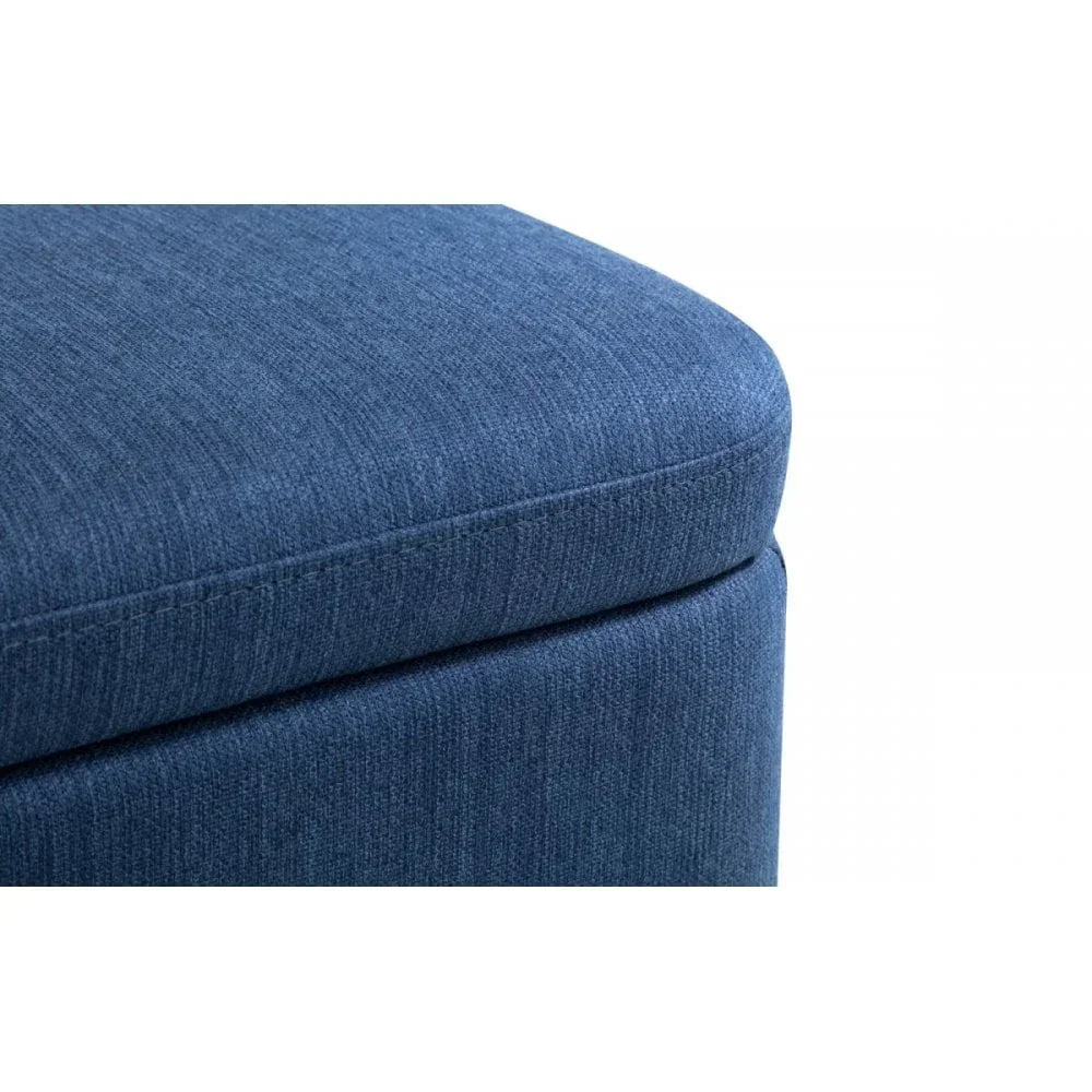 Closeup of blue fabric ottoman corner with soft upholstery and visible stitching detail