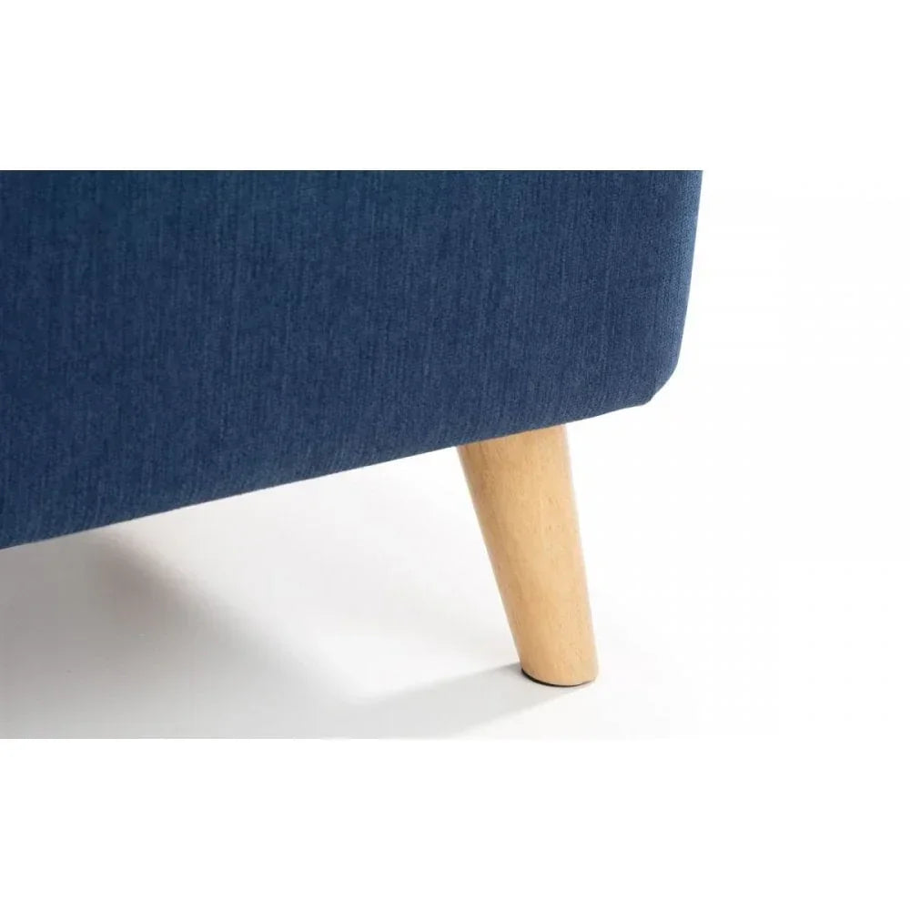 Closeup of blue sofa fabric upholstery with angled wooden leg on white background