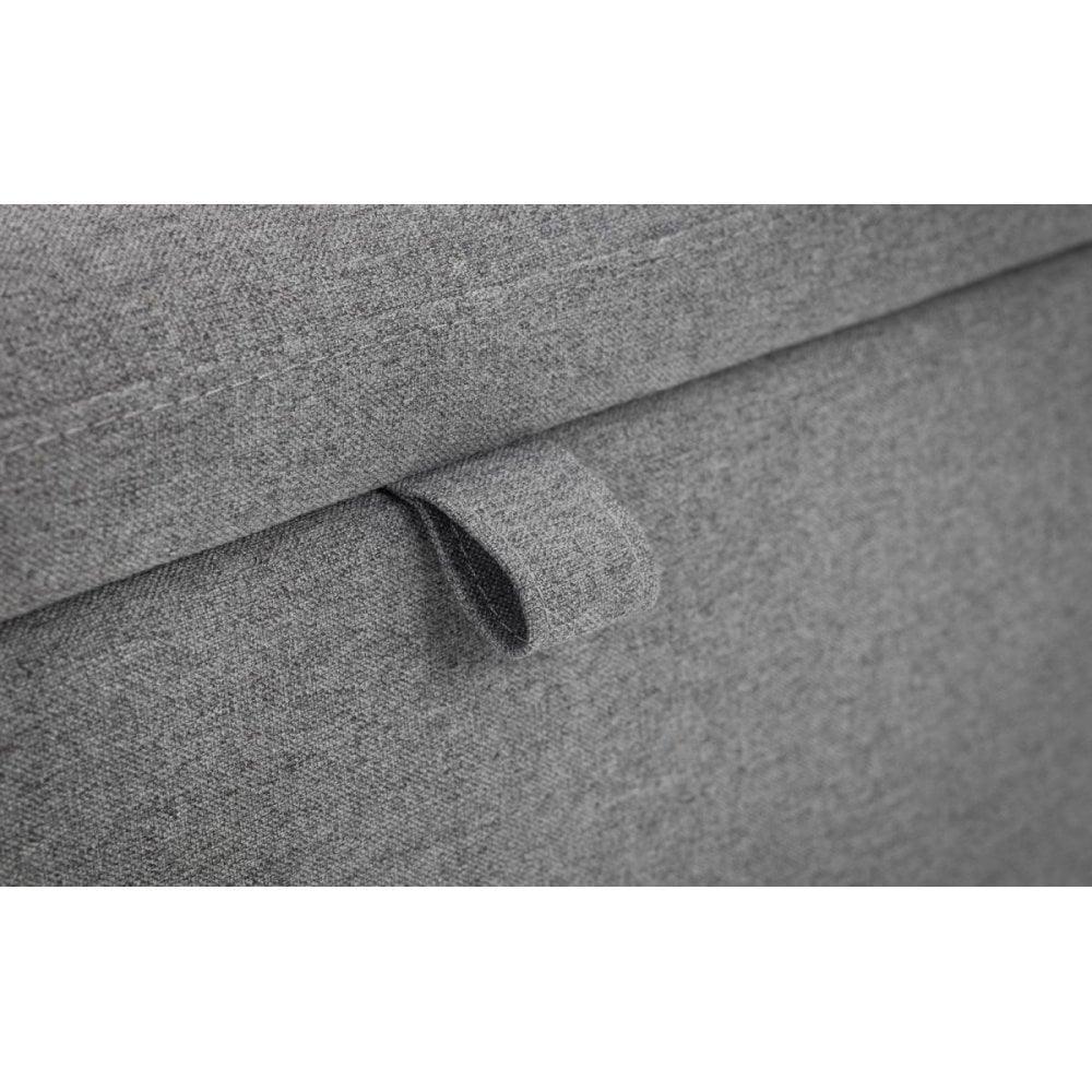 Closeup of grey fabric ottoman storage bench pull tab and stitching detail