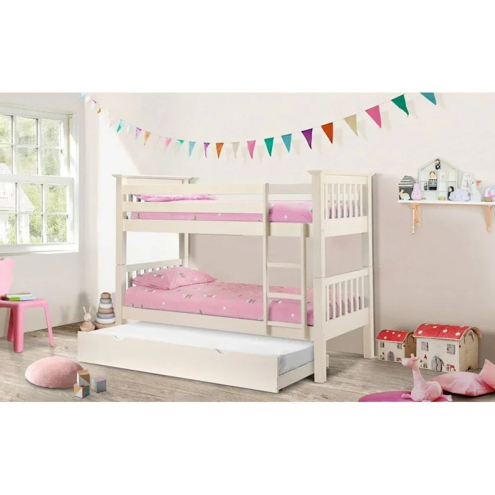 White wooden bunk bed with trundle and pink bedding in a bright children's bedroom