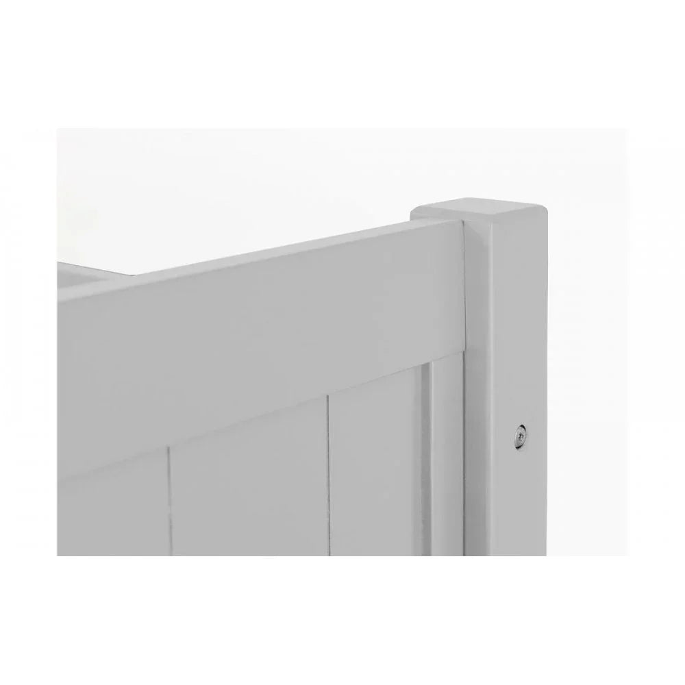 Detail of white wooden bed frame corner with panel design and smooth painted finish