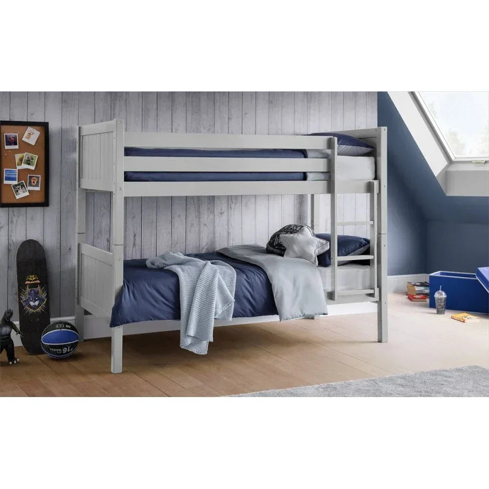 Grey wooden bunk bed with blue bedding in kids' bedroom, ladder on right, sloped ceiling window