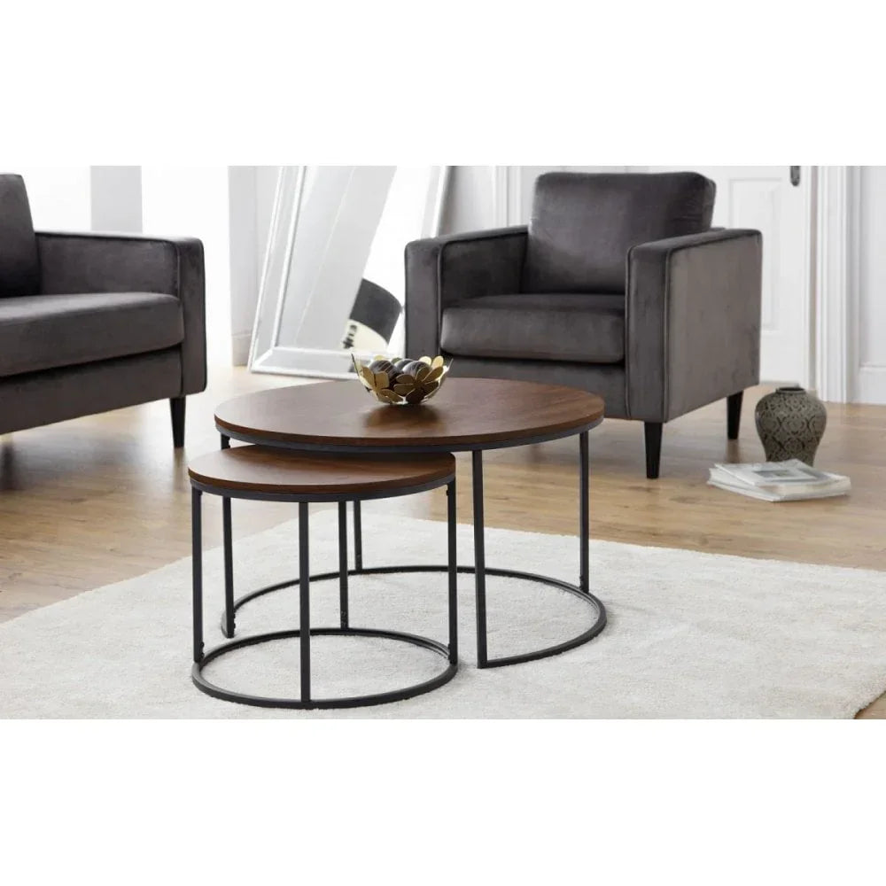 Round wooden nesting coffee tables with black metal frames in modern living room setting