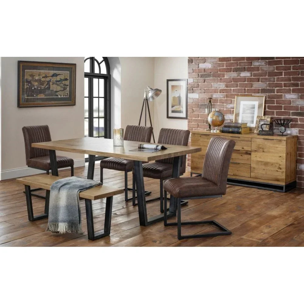 Industrial dining table set with wooden bench and brown faux leather chairs in loft dining room