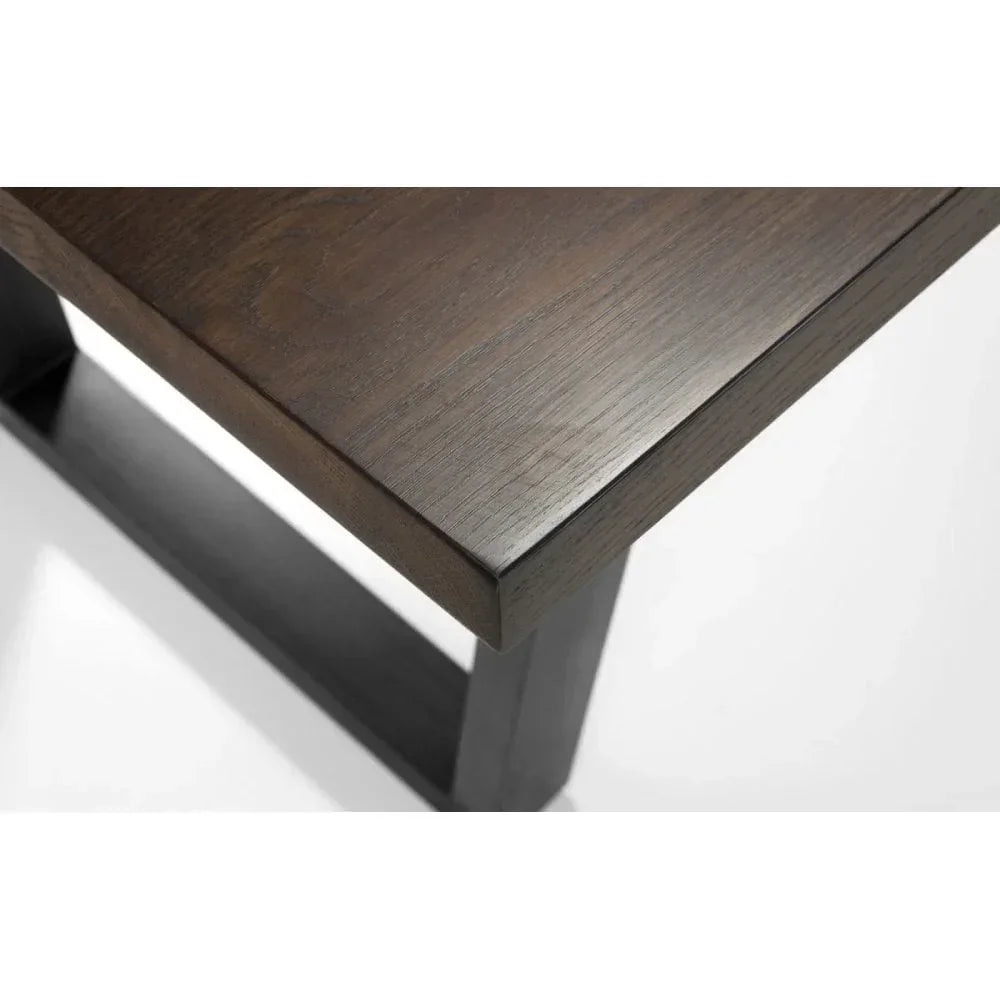 Dark wood dining table corner with visible grain and sturdy leg design