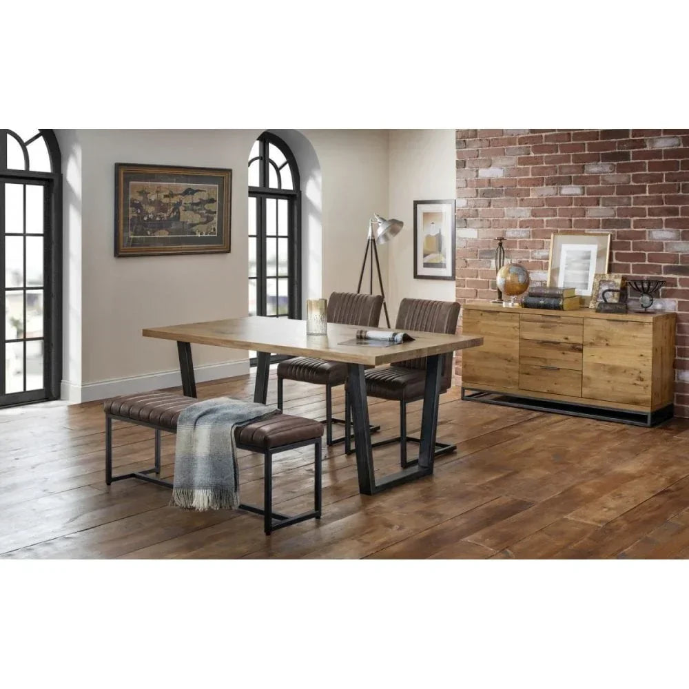 Industrial dining table set with wood top, leather bench, and matching sideboard in loft-style room