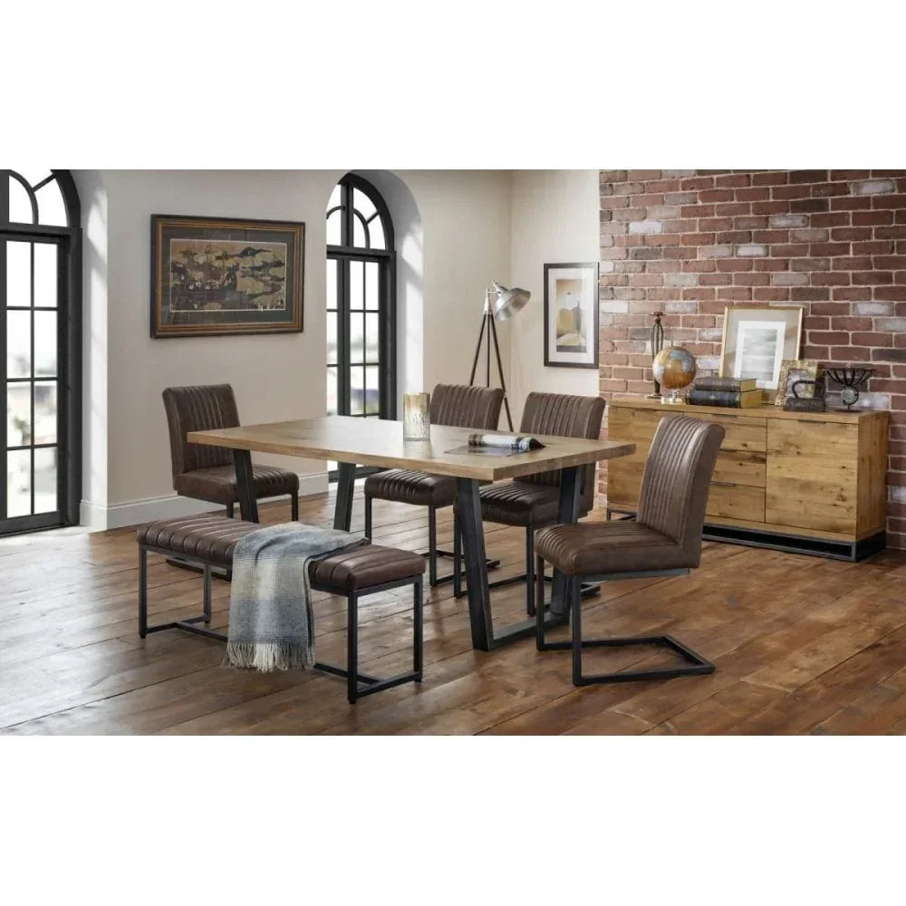 Industrial dining table set with brown leather chairs and bench in loft-style room