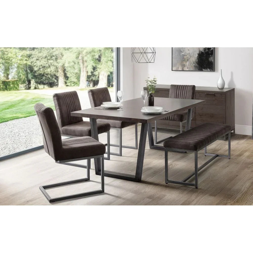 Modern dining table set with grey chairs and bench on wooden floor in bright dining room