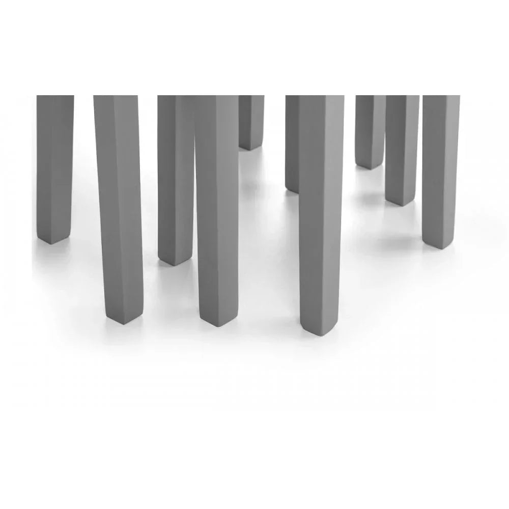 Closeup of grey dining table and chair legs on white floor