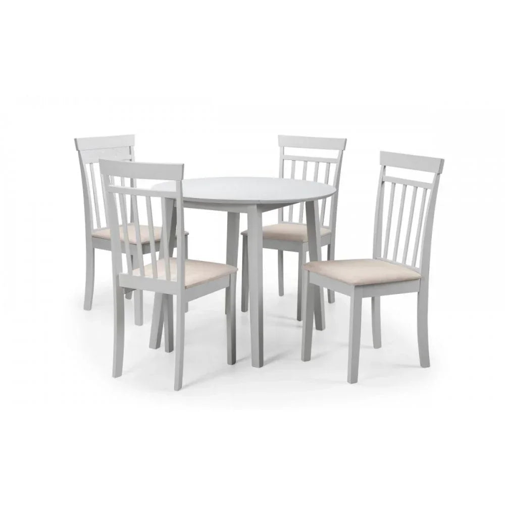 White wooden dining table with round top and four matching chairs, beige seat cushions