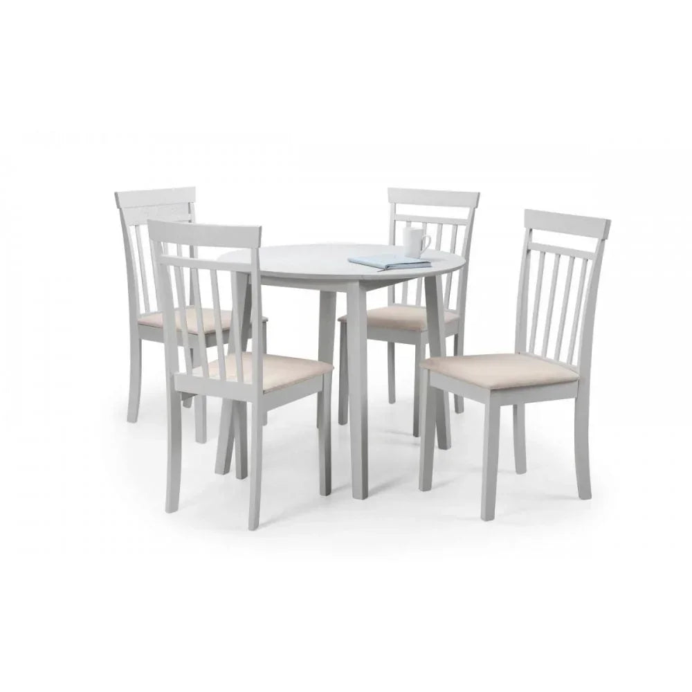 White dining table set with four slatted back chairs and cushioned seats on white background