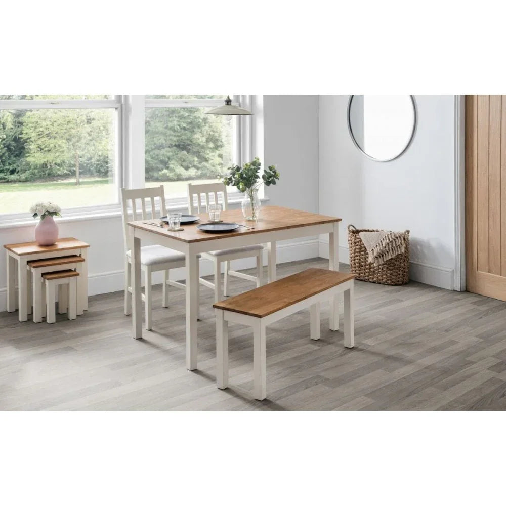Wood dining table set with two chairs, bench, and matching nesting tables in bright room