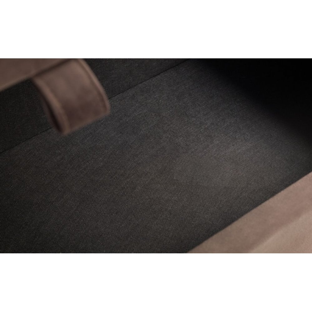 Close view of storage ottoman interior with dark fabric lining and brown fabric edge
