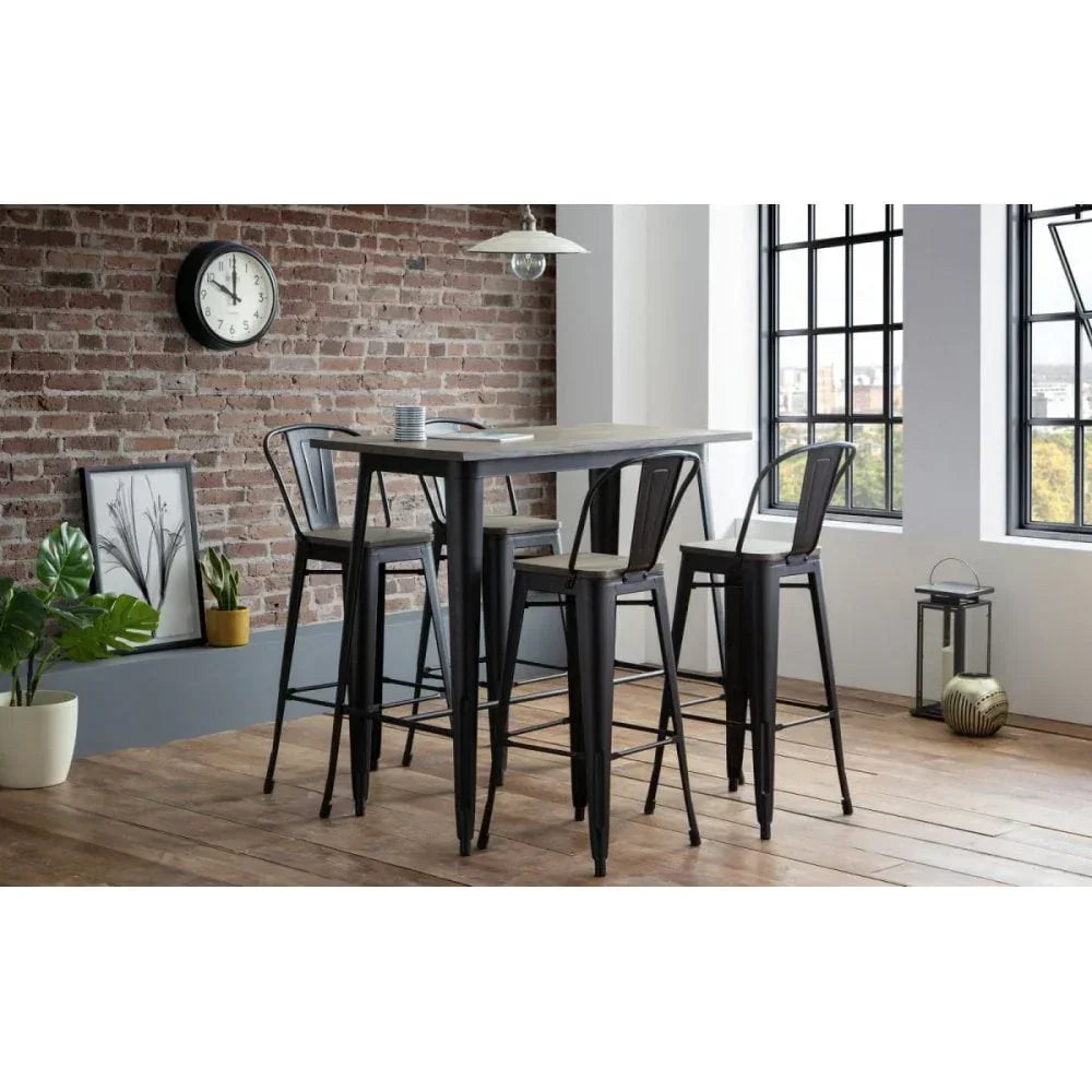 Industrial bar table with four black metal stools in modern dining room with brick wall