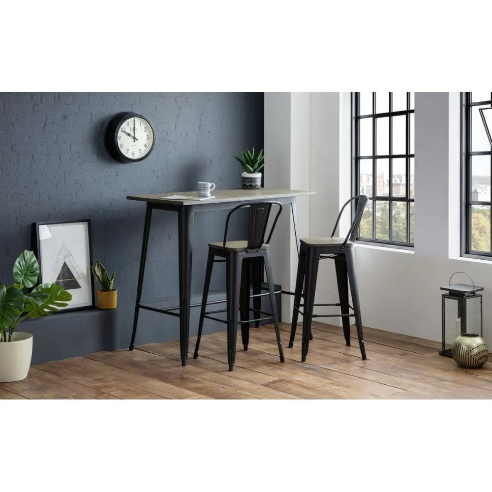Industrial bar table with two metal bar stools in modern dining room with plants