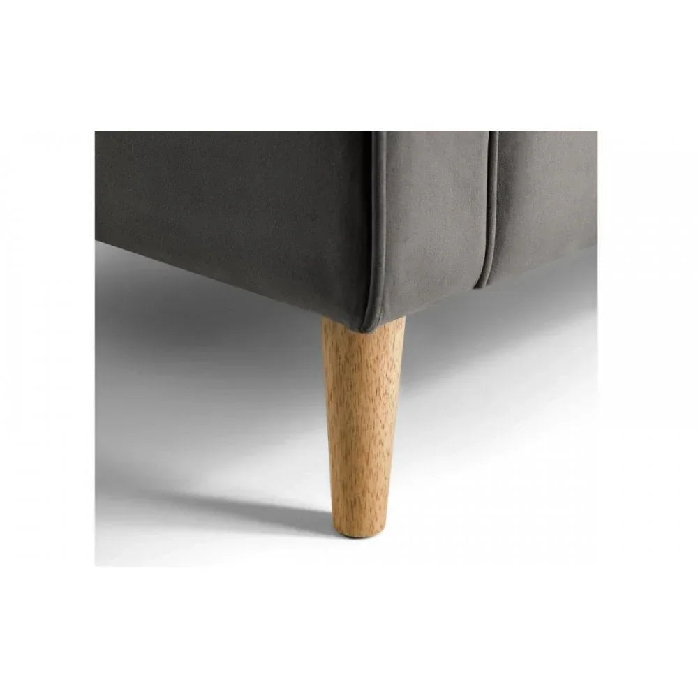 Close view of grey sofa corner with wooden leg on white background