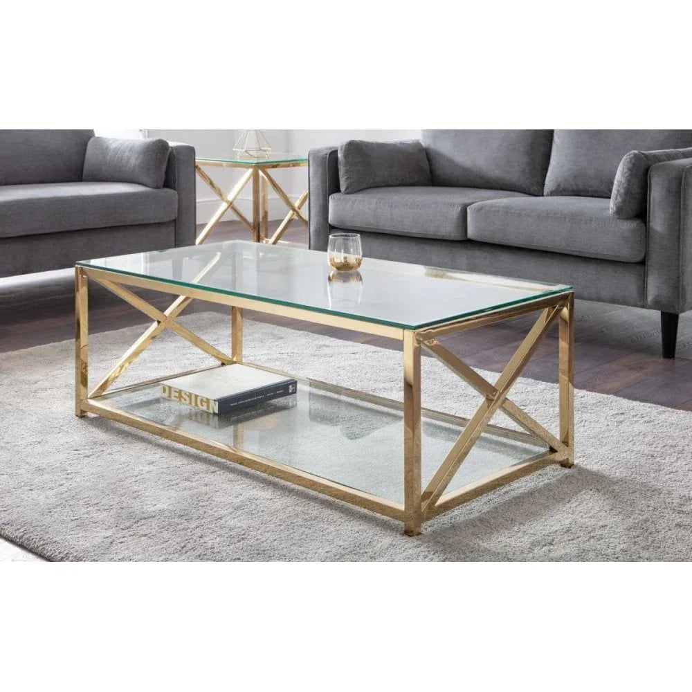 Glass coffee table with gold metal frame on grey rug between two grey sofas