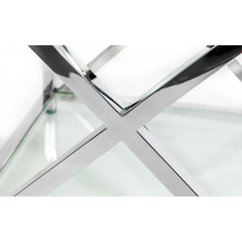 Close-up of chrome and glass coffee table frame with X-shaped leg design