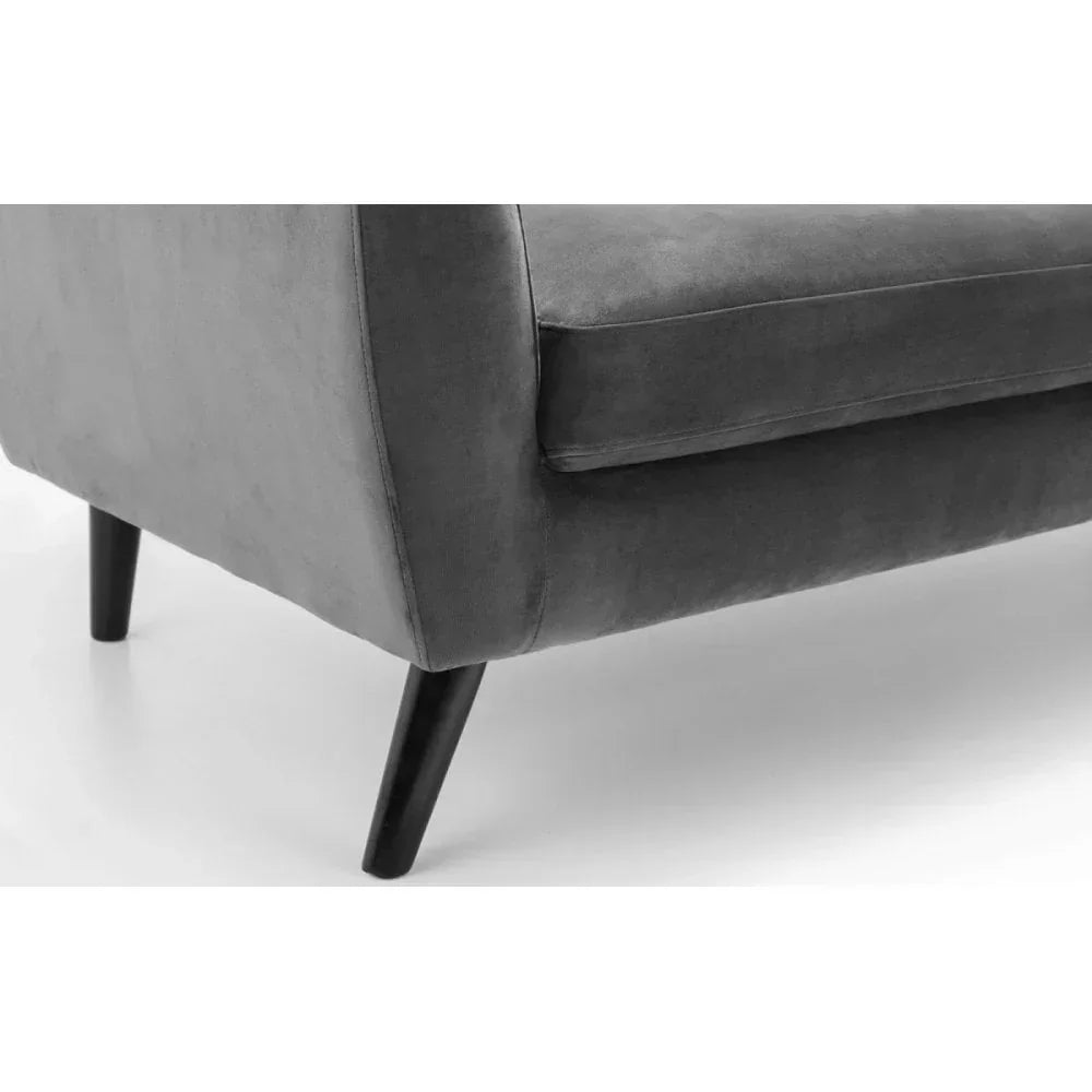 Close-up of grey velvet sofa corner with black angled wooden legs