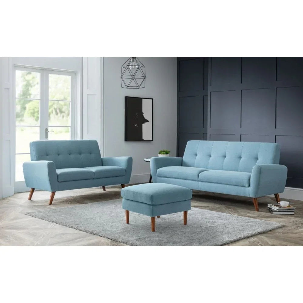 Light blue fabric sofa set with matching footstool and rug in modern living room
