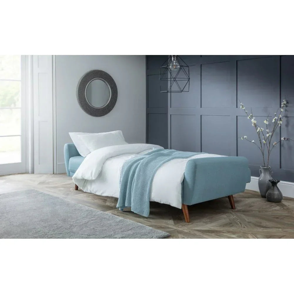 Modern blue upholstered bed with white bedding in a stylish bedroom setting