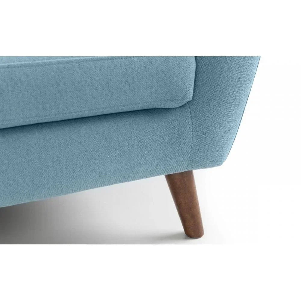 Blue fabric sofa corner with wooden tapered leg on white floor
