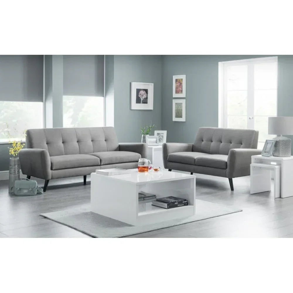 Grey fabric sofa set with tufted backs in modern living room, white coffee table in front