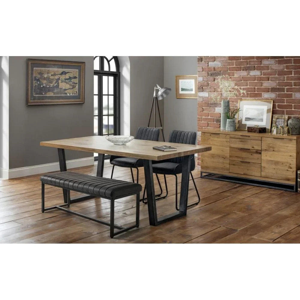 Industrial dining table set with black chairs and bench on wooden floor in modern dining room