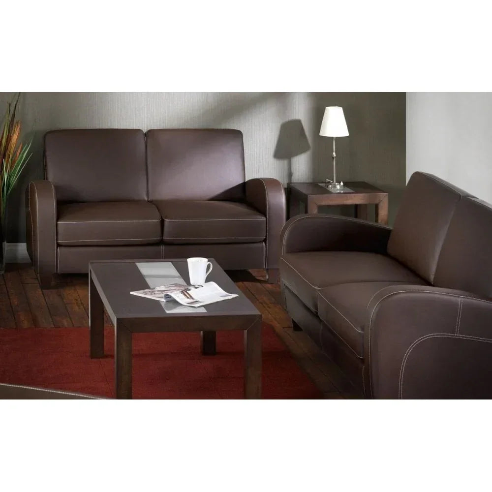 Brown leather sofa set in living room with glass coffee table and side lamp