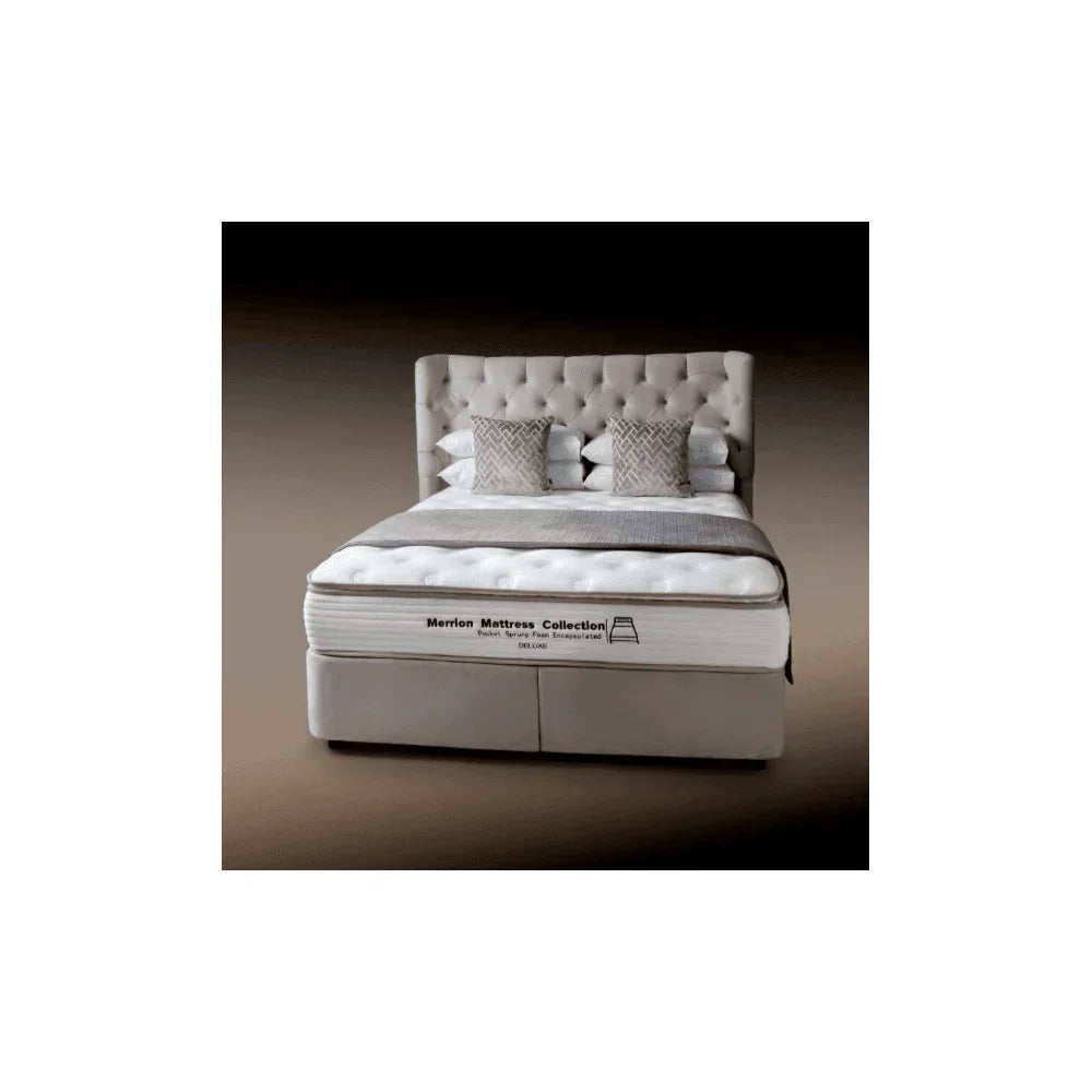 Tufted upholstered bed frame with mattress and pillows, front view, neutral tones