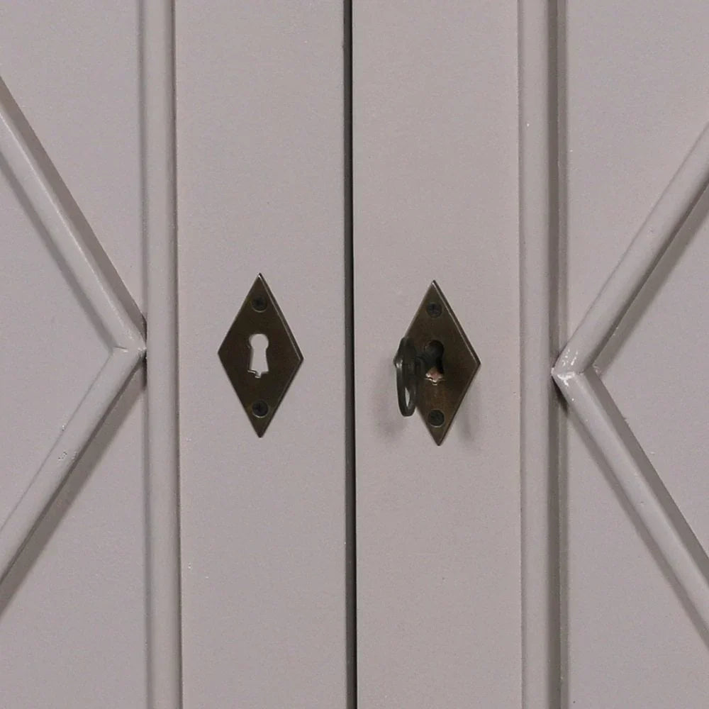 Closeup of cabinet door with brass keyhole escutcheons and geometric wood detailing
