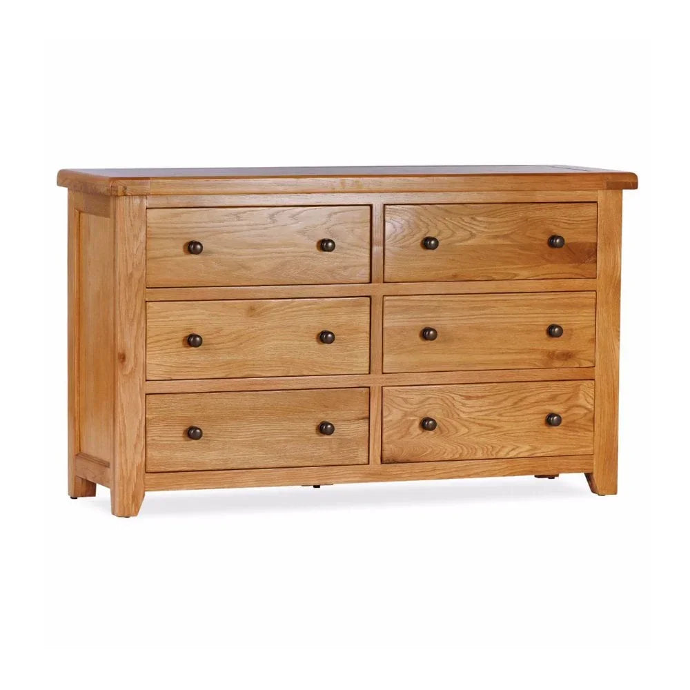 Oak chest of drawers with six drawers and round metal knobs on white background