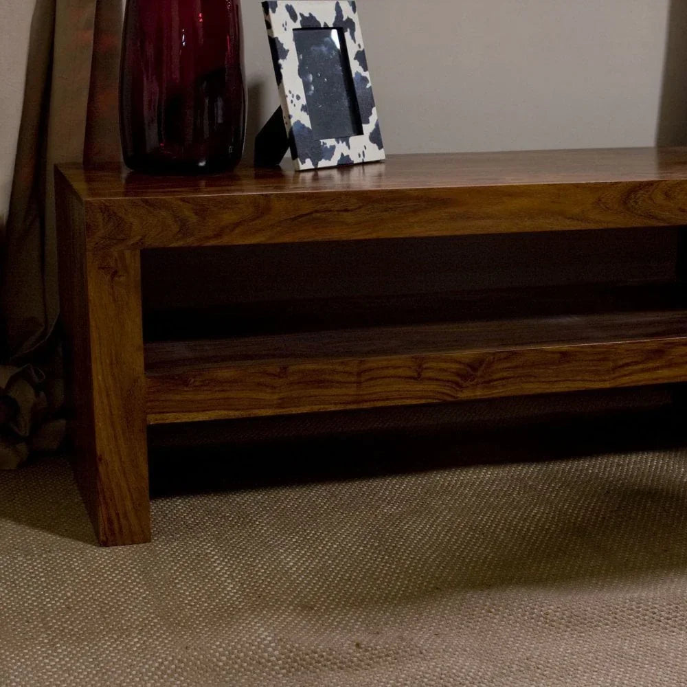 Solid wood coffee table with shelf, styled with red vase and picture frame