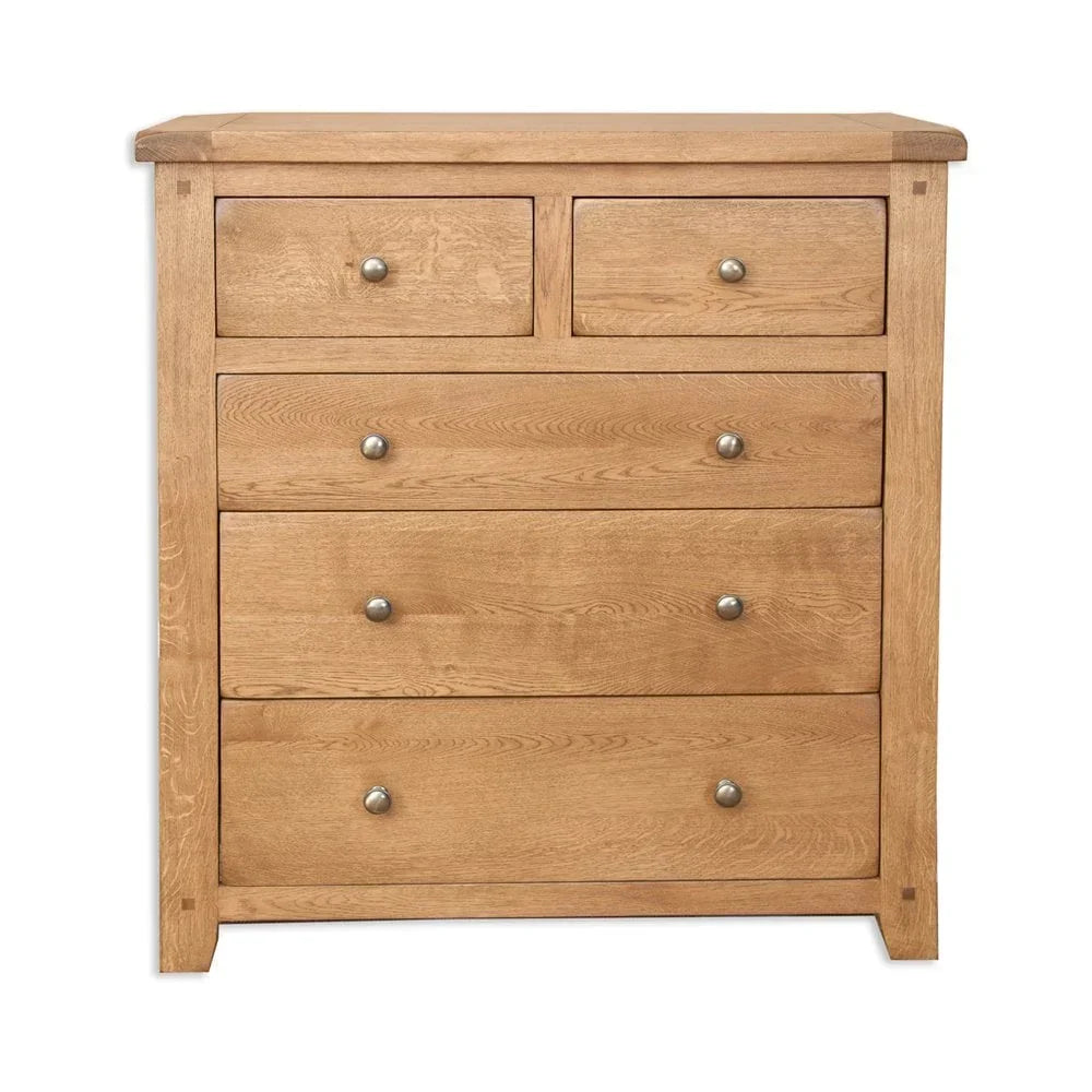 Oak chest of drawers with five drawers and metal knobs, front view against white background