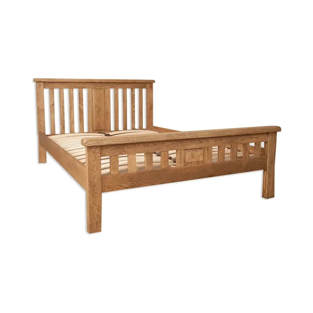 Solid oak bed frame with slatted headboard and footboard, angled side view